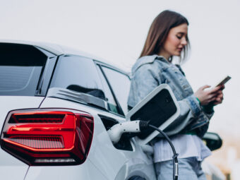 Woman charging her electric car with charging pistol